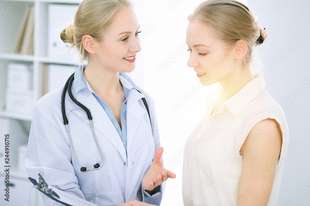 Doctor and patient talking in hospital office while sitting at the desk. Health care and client service in medicine Doctor and patient talking in hospital office while sitting at the desk. Health care and client service in medicine