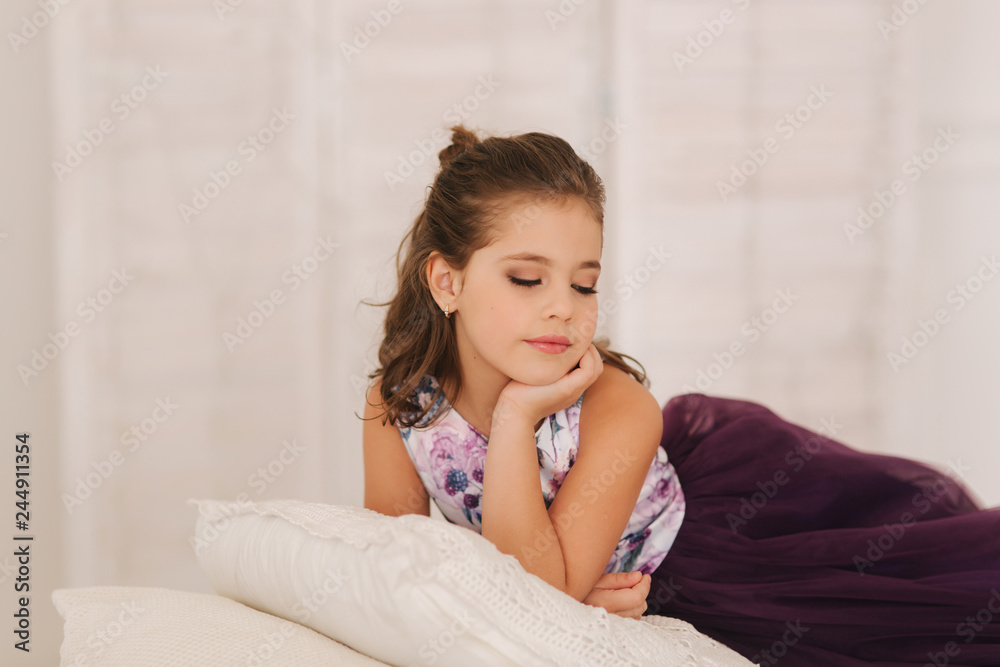 Happy child female in purple dress. Beautiful makeup and hairstyle Happy child female in purple dress. Beautiful makeup and hairstyle