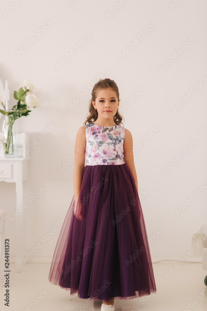 Happy child female in purple dress. Beautiful makeup and hairstyle Happy child female in purple dress. Beautiful makeup and hairstyle