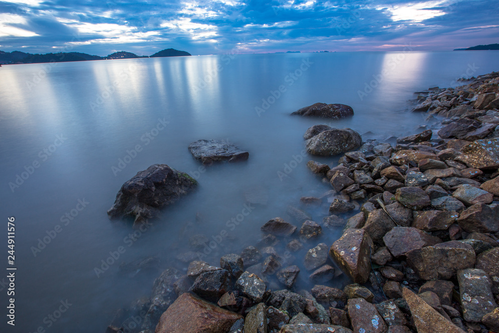 Obraz premium An abstract background of water that is moving or calm along the beach along the rocks of various sizes, natural wallpapers by the lake, looking at one type of natural art without being manipulated.