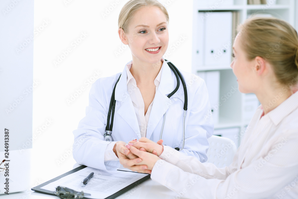 Doctor and patient talking in hospital office while sitting at the desk. Health care and client service in medicine Doctor and patient talking in hospital office while sitting at the desk. Health care and client service in medicine
