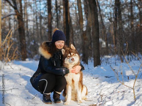 Girl with a dog husky in the winter in the park