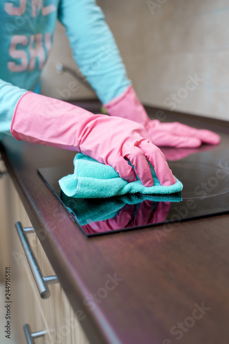 Image of hands in pink rubber gloves washing hob