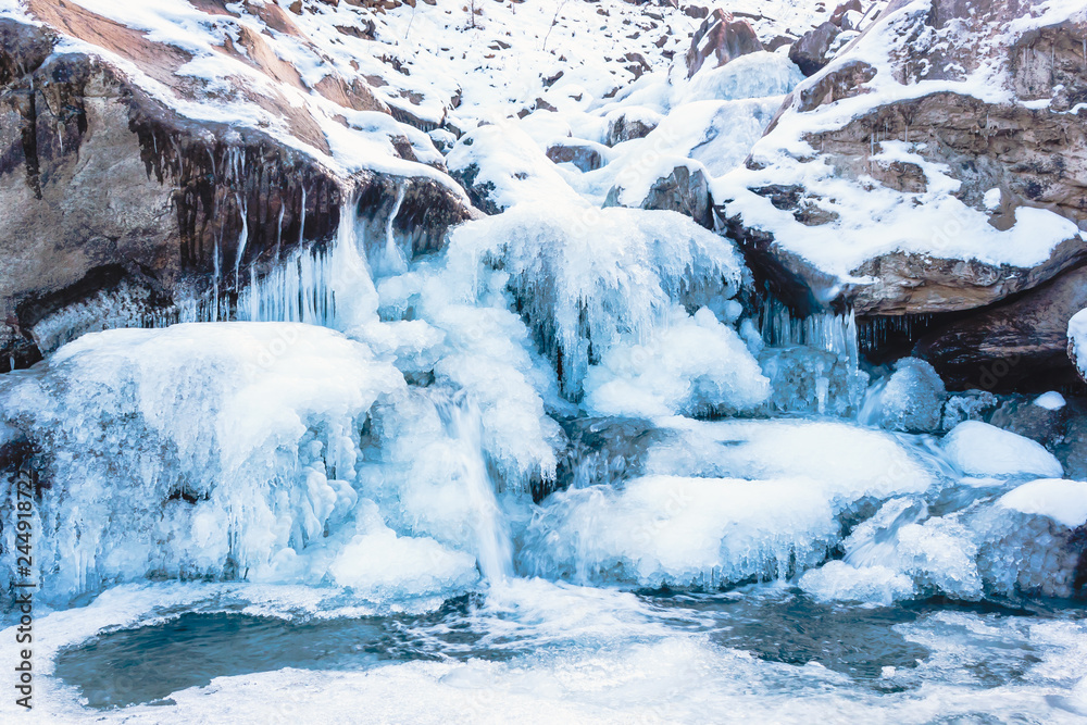 Winter mountain river under ice. Water froze and turned into icicles. Winter mountain river under ice. Water froze and turned into icicles.