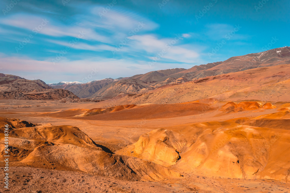 Yellow and red rocks under blue sky. Desert landscape with mountains.