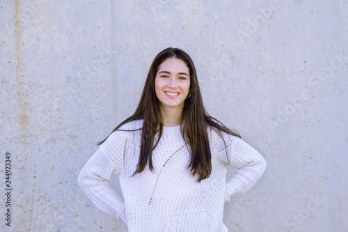 Happy girl with perfect white teeth and smile wearing a white sweater looking at camera - Image