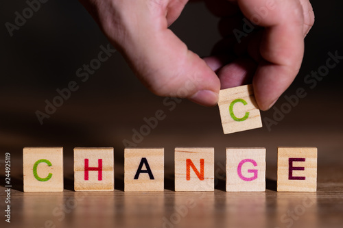 Hand setzt einen Buchstaben und zeigt, das Veränderung gleichzeitig eine Chance ist photo