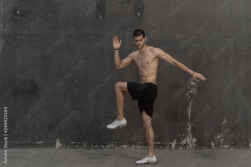 Young athlete man, naked torso, running against a gray wall Young athlete man, naked torso, running against a gray wall