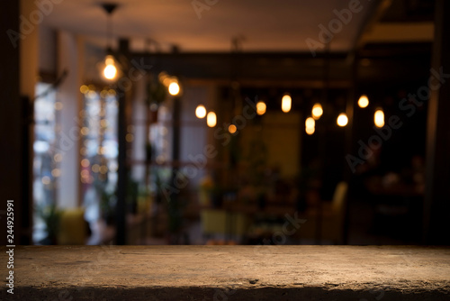 image of wooden table in front of abstract blurred background of resturant lights