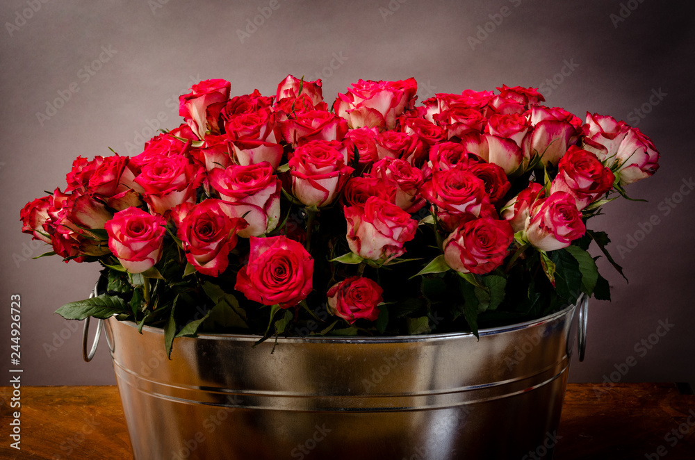 lots of roses in a bucket well suited for the valentines day