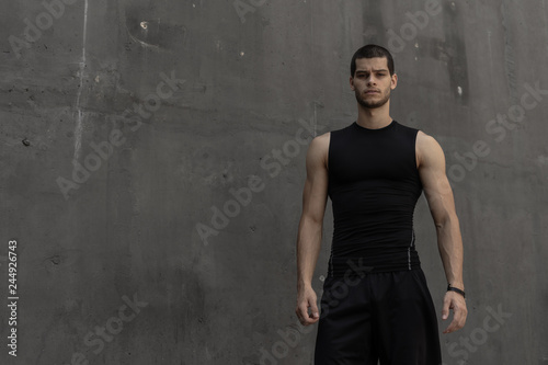 Sport model man posing gray wall background