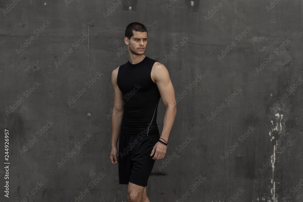 Sport model man posing gray wall background