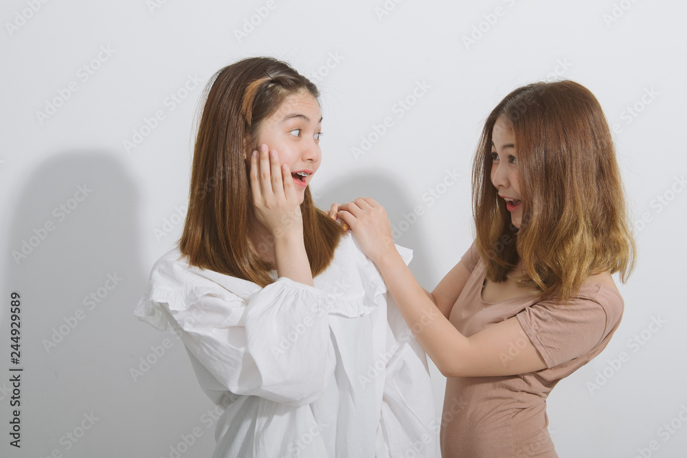 Portrait of surprised asian females look with terrified expressions, two cute asian woman whispering a secret isolated over grey background. Portrait of surprised asian females look with terrified expressions, two cute asian woman whispering a secret isolated over grey background.