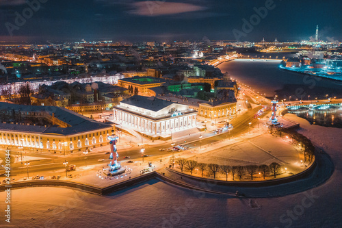 Aerial view of Rostral Columns in Vasilievskiy Island, night lights, river Neva frome drone