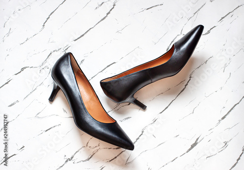 Kitten heel court shoes on the white marble background. Top view