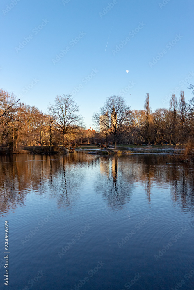 Teich im Park mit Romantischen Brücken,Kirche im Winter in Leipzig mit blauen Himmel