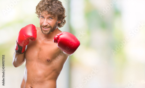 Handsome hispanic boxer man wearing boxing gloves over isolated background with a happy and cool smile on face. Lucky person.