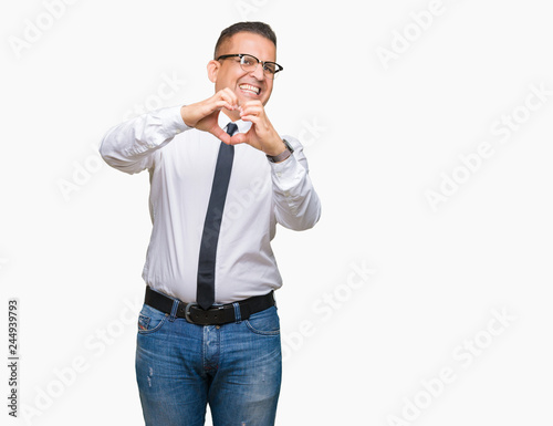 Middle age bussines arab man wearing glasses over isolated background smiling in love showing heart symbol and shape with hands. Romantic concept.