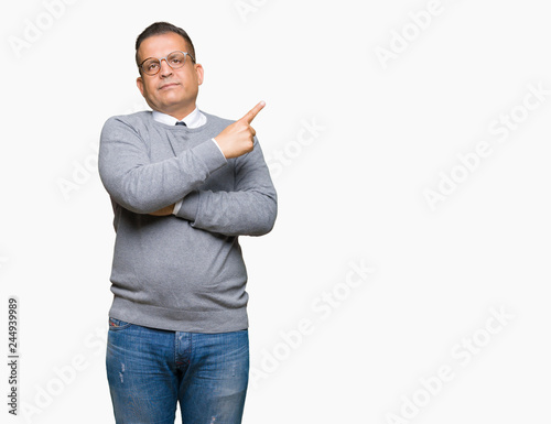 Middle age bussines arab man wearing glasses over isolated background Pointing with hand finger to the side showing advertisement, serious and calm face
