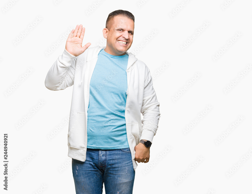 Middle age arab man wearing sweatshirt over isolated background Waiving saying hello happy and smiling, friendly welcome gesture Middle age arab man wearing sweatshirt over isolated background Waiving saying hello happy and smiling, friendly welcome gesture