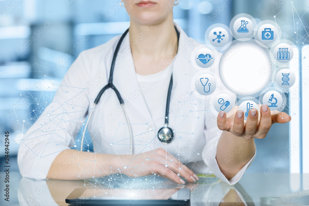 A doctor is sitting and holding a circle of icons with medical symbols.