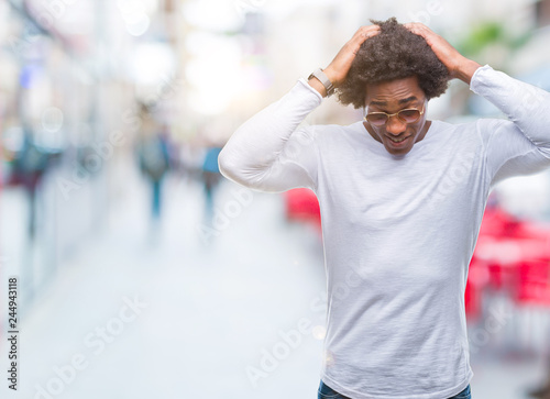 Afro american man wearing sunglasses over isolated background suffering from headache desperate and stressed because pain and migraine. Hands on head.