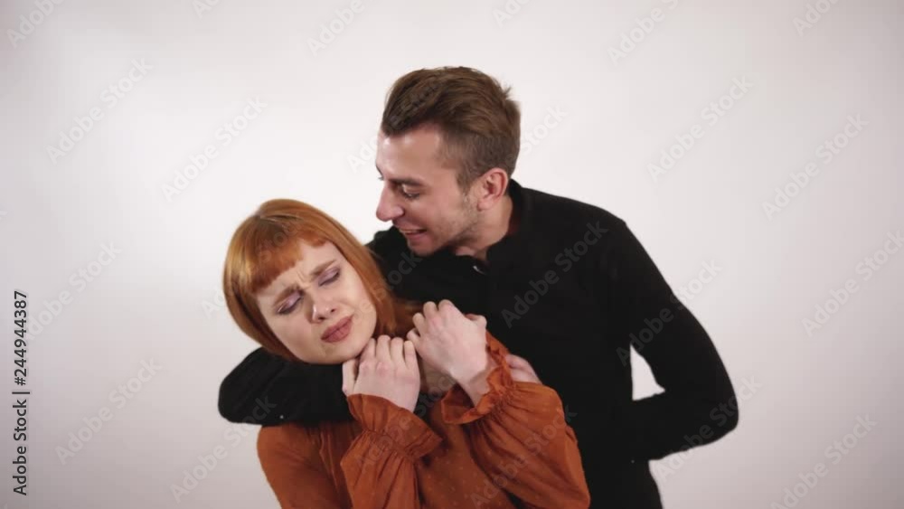 Violent aggressive man strangle womans throat and yelling at girl, crying female with long red try to protect herself. Violent aggressive man strangle womans throat and yelling at girl, crying female with long red try to protect herself.
