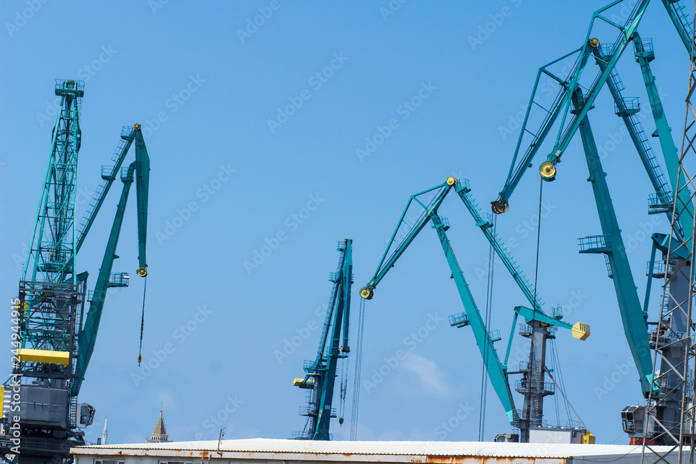Industrial cranes in seaport. Container terminal in sea dock.
