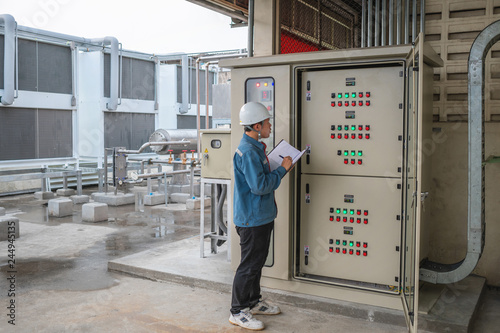 Photography Young engineer checking temperature of refrigeration and setting temperature of