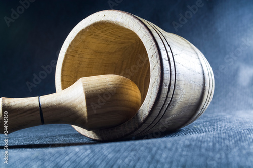 Empty brown mortar with a pestle wooden. A drinking bowl for crushing of spices. Black background. Kitchen utensils. Ware.