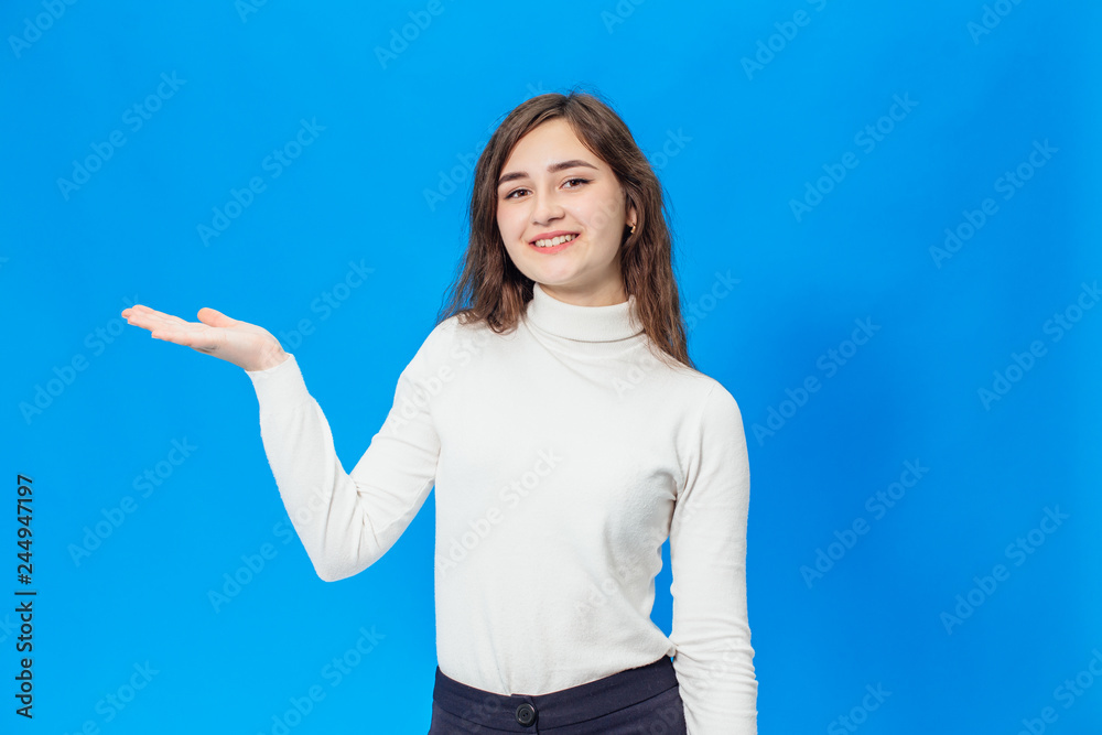 Fototapeta premium Young beautiful girl isolated on blue background