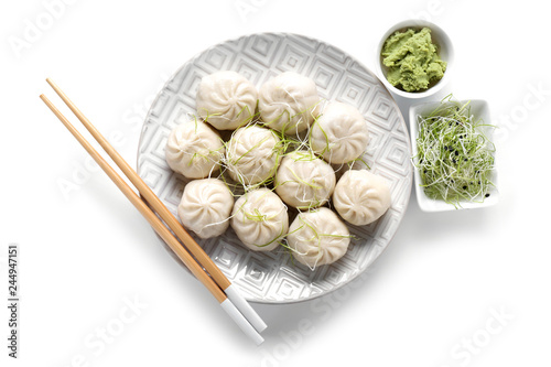 Plate with tasty Chinese dumplings, wasabi and sprouts on white background