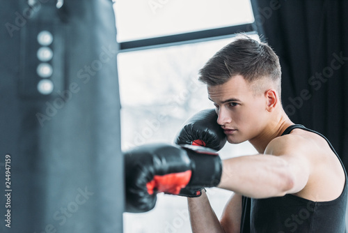 concentrated young sporty man boxing with punching bag in gym © LIGHTFIELD STUDIOS