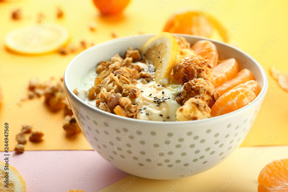 Tasty granola with yogurt and fruits in bowl on color background Tasty granola with yogurt and fruits in bowl on color background