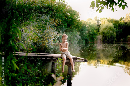 Little boy fishing on lake.