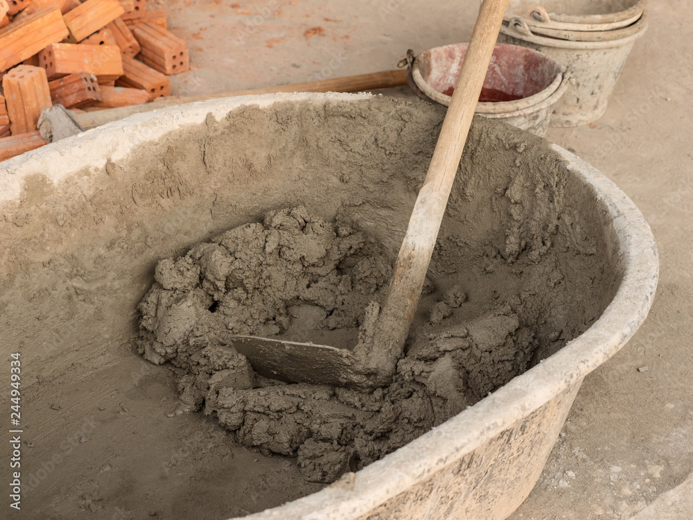 Mixing cement in basin in construction site Mixing cement in basin in construction site