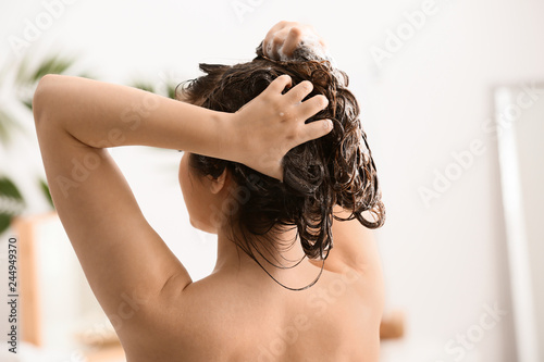 Young woman washing her beautiful hair in bathroom
