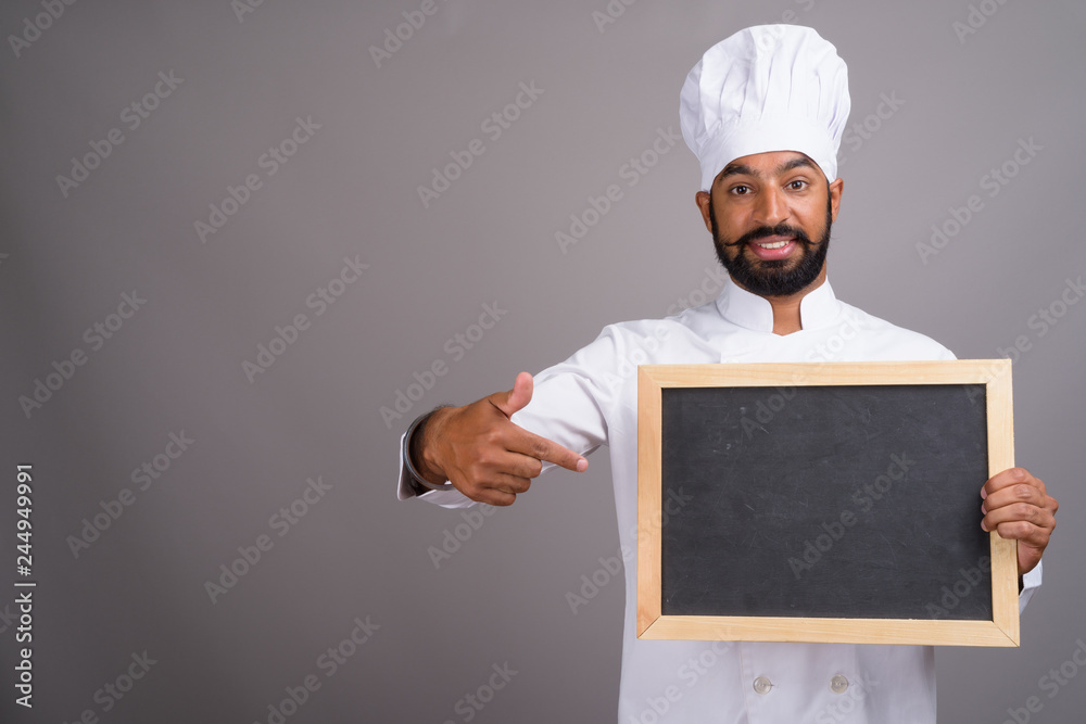Indian man chef holding empty black board with copy space Indian man chef holding empty black board with copy space