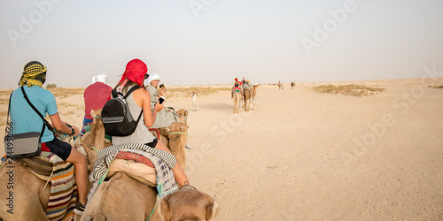 DOUZ, TUNISIA - JULY 22, 2018: A girl ride on camel in the Sahara desert, Tunisia, Africa