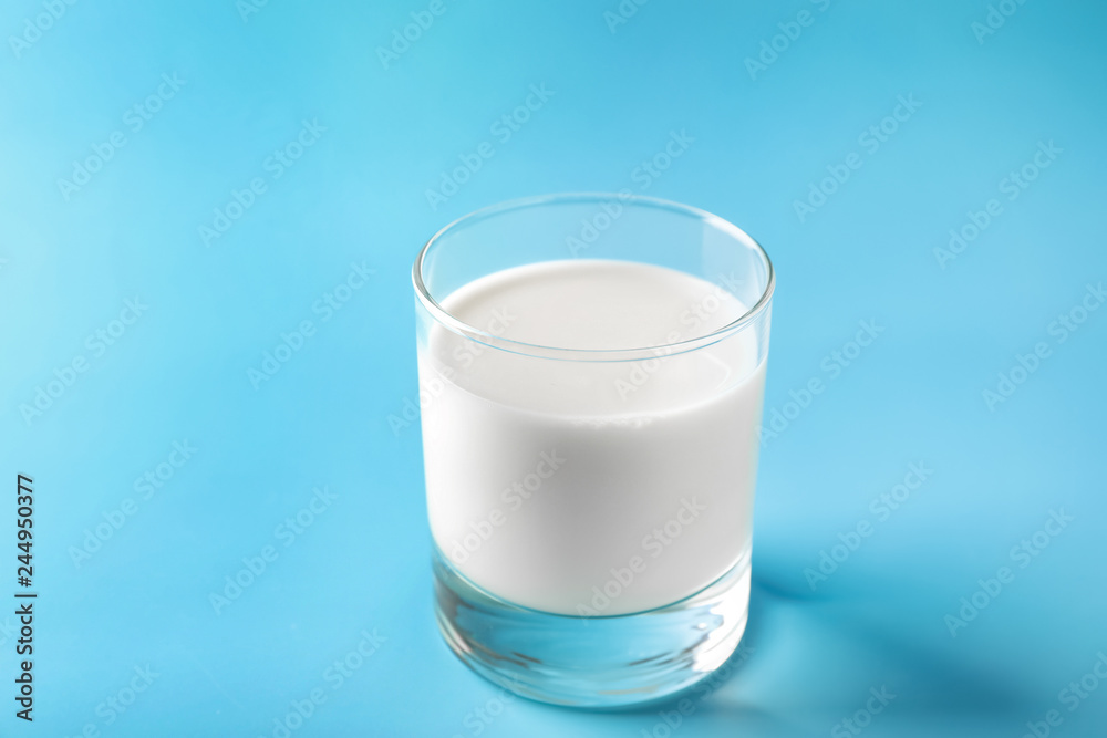 Glass of tasty milk on color background