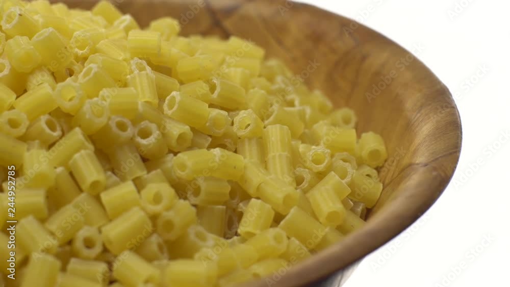Raw macaroni in rotation. Ditalini lisci. Close up. Raw pasta isolated on white. Italian cuisine concept. Raw macaroni in rotation. Ditalini lisci. Close up. Raw pasta isolated on white. Italian cuisine concept.