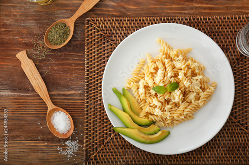 Plate with tasty pasta and avocado on table