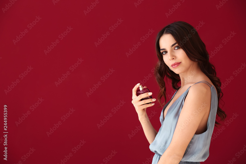 Beautiful young woman with bottle of perfume on color background Beautiful young woman with bottle of perfume on color background