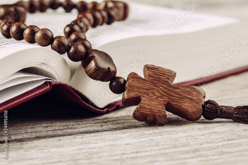 Fényképezés Bible and a crucifix on an old wooden table. Religion concept.