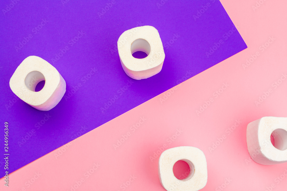 White toilet paper rolls on bright color block background White toilet paper rolls on bright color block background