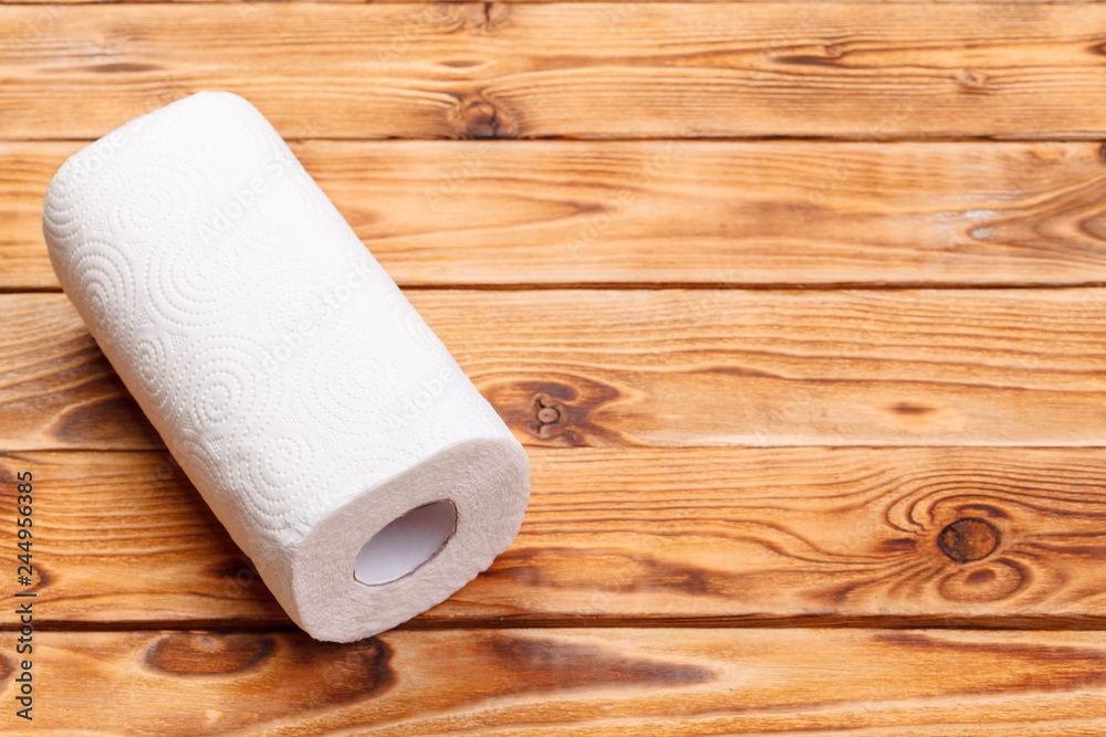 Fototapeta premium Roll of paper towel on wooden background