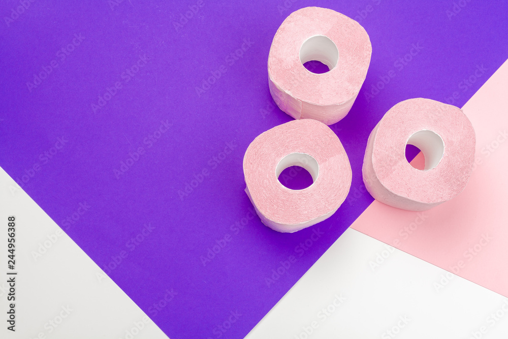 Pastel pink toilet paper on bright color block background Pastel pink toilet paper on bright color block background