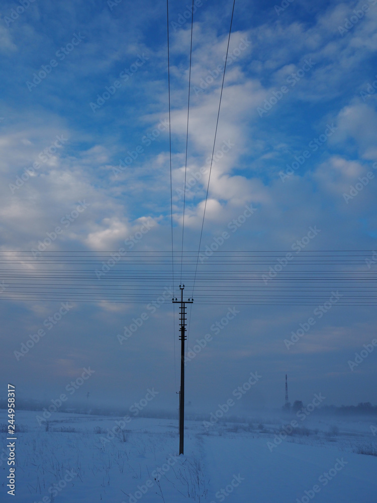 Electric support and crossed wires on a background of blue sky, vertical view Electric support and crossed wires on a background of blue sky, vertical view