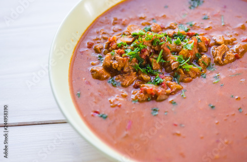 Rindfleischeintopf oder Gulaschsuppe mit Fleischstücken in roter Tomaten sauce photo