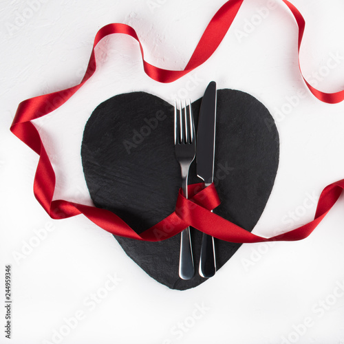 Heart shaped black plate dinner or lunch table setting for valentine day romantic celebration